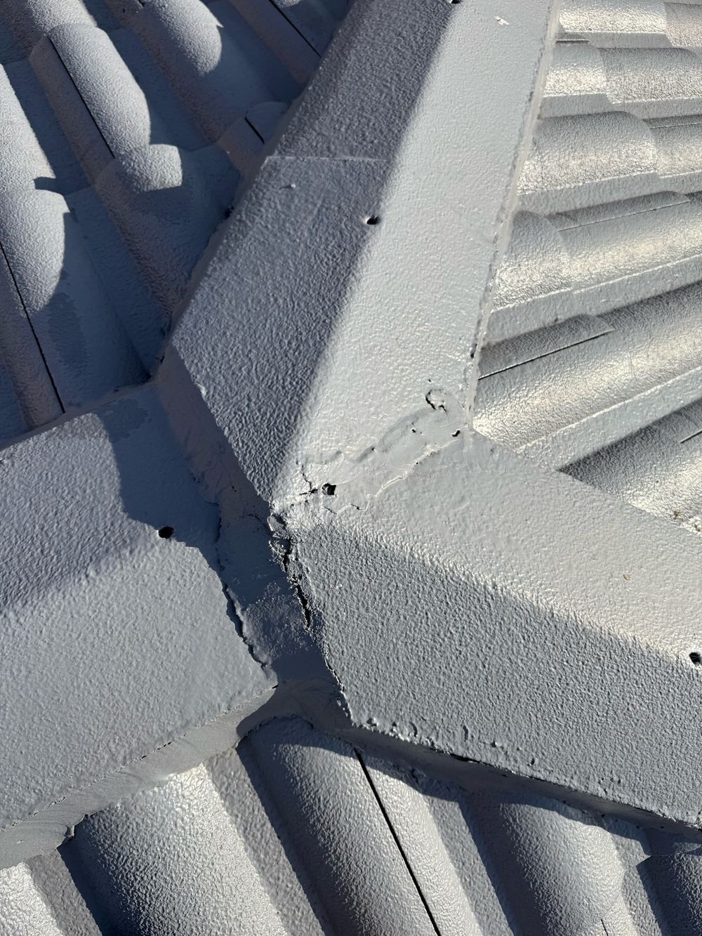 Open gaps in the ridge capping pointing where roof sections meet, found during a defect investigation inspection in Aspendale Gardens