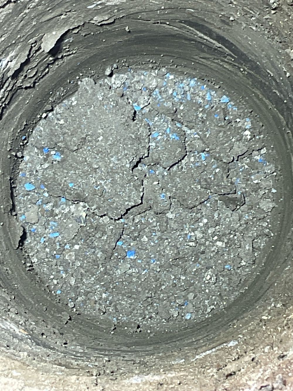 Loose spoil in the bottom of a bored pier that must come out before concrete, found during a bored pier inspection in Lara